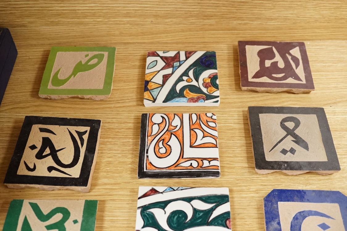 A Berber sixteen tile set, North African to read 'God is Great', floral tiles 10cm square
